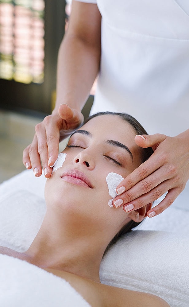 Woman receiving a facial treatment in spa.